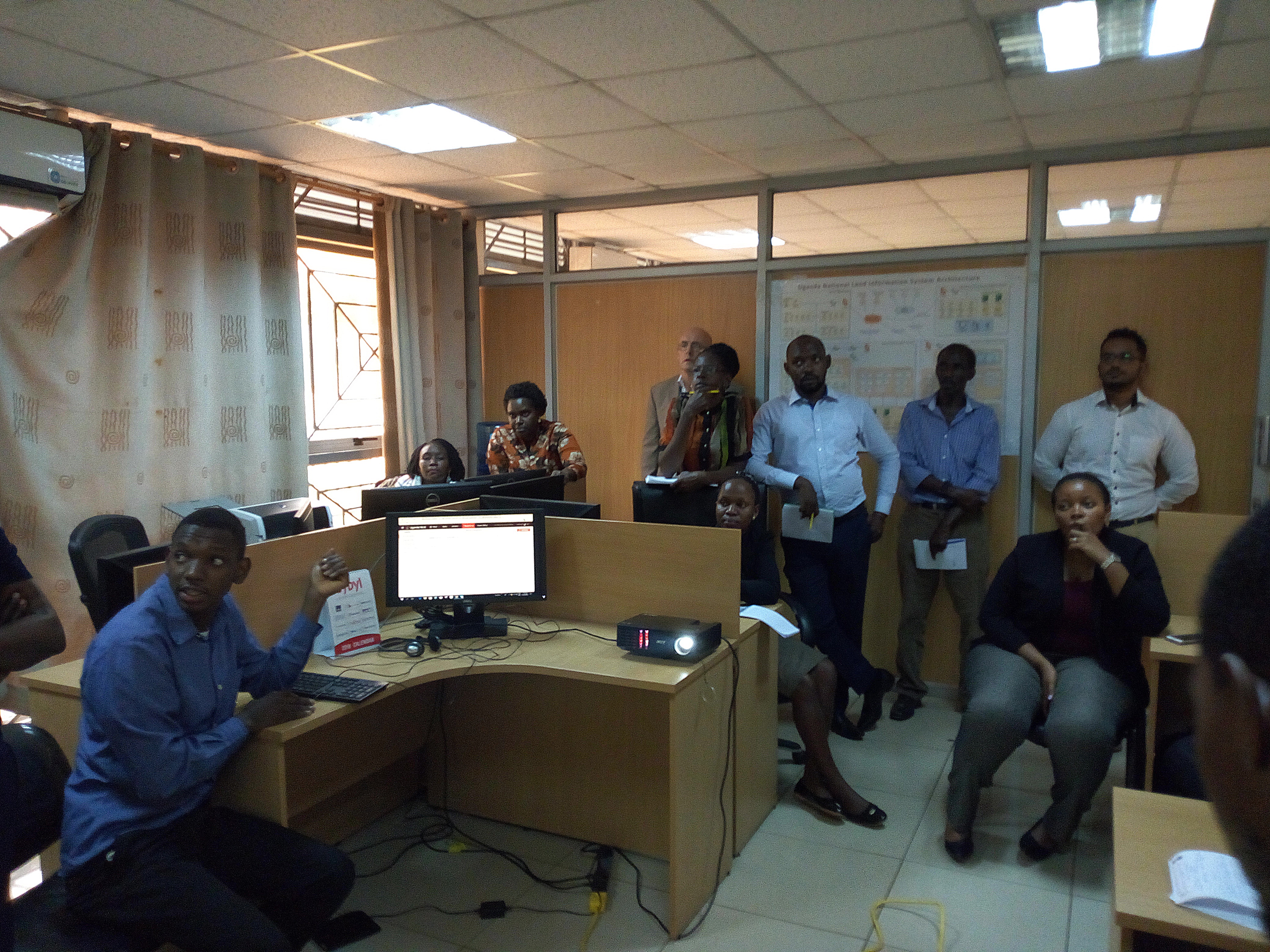 Members of the NES steering committee attending to a demonstration of the new NLIC system as demonstrated by Mr. Brian Sserukawe of the Ministry of Lands Housing and Urban Development.
